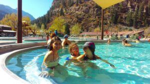 A family enjoying the shallow pool at Ouray Hot Springs, perfect for kids and parents alike.