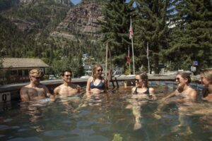 Visitors enjoying a relaxing soak at Ouray Hot Springs Pool, surrounded by scenic mountain views.